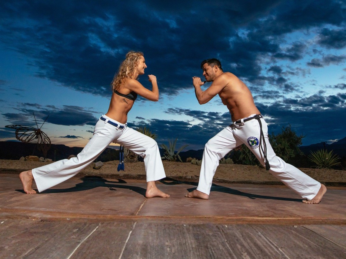 Two adults in ginga, the base movement of capoeira